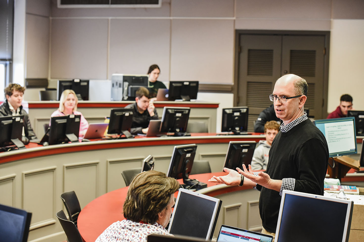 A college professor talks to a room full of students